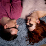 парень и девушка лежат на кровати и смеются